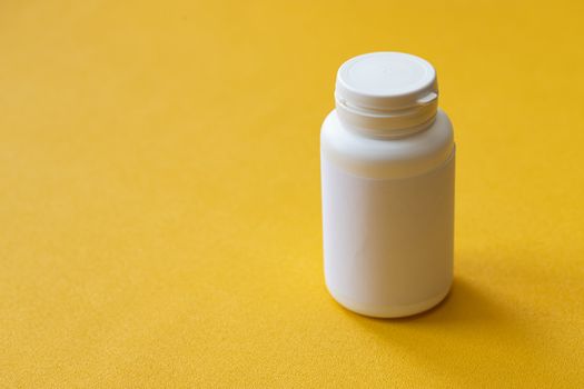 tablet bottle of medicine, photo isolated on a yellow background. Mock-up.