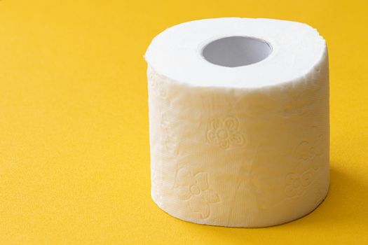 Close-up image of toilet roll isolated on yellow background, copy space for your design or text
