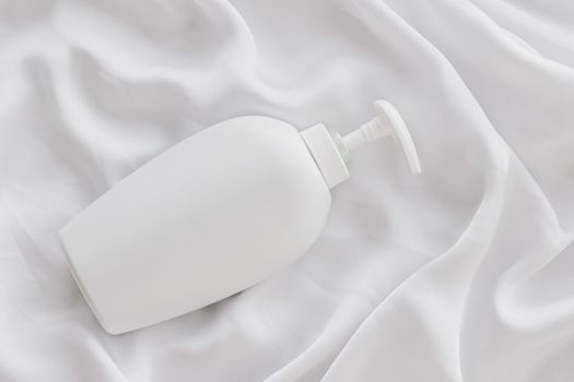 Blank label cosmetic container bottle as product mockup on white silk background, hygiene and healthcare