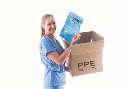 Nurse or doctor holding a Category 3 Type 5 disposable coverall hasmat suit PPE for infection control.  Infection control and correct PPE is important during infectious or contagious pandemics.