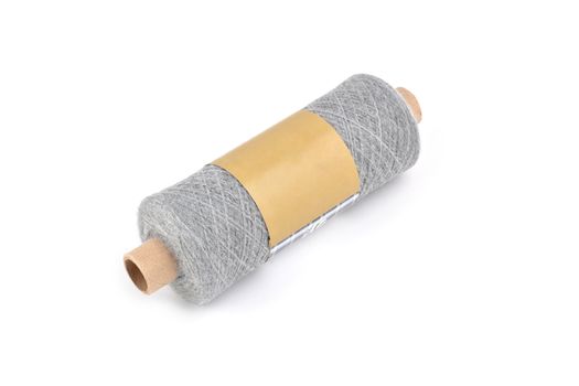 Color bobbin of yarn with label. Side view. Textile reel on isolated white background. Use for store