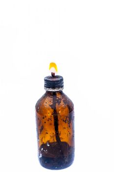 Close up of a bottle shaped kerosene lamp or oil lantern isolated on white burning.