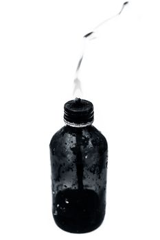 Close up of a bottle shaped kerosene lamp or oil lantern isolated on white burning.