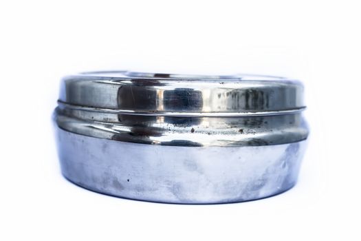 Close up of circular domestic stainless steel container isolated on white used to store, preserve etc.