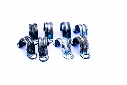 Close up of bunch of aluminum pipe clamp or clip isolated on white.