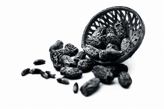 Close up shot of raw dried dates or kharek or sukhi khajoor or Phoenix dactylifera in a hamper isolated on white.