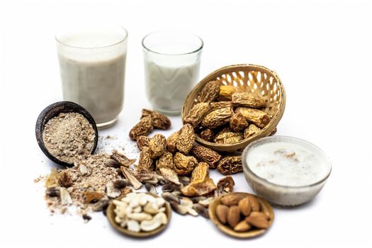 Close up of popular Indian and asian Winter drink isolated on white i.e. Kharek ka dudh or dried dates milk consisting of milk,dried dates,cashews,almonds dry fruits and sugar.