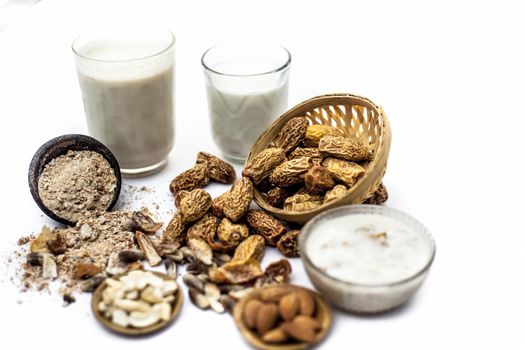 Close up of popular Indian and asian Winter drink isolated on white i.e. Kharek ka dudh or dried dates milk consisting of milk,dried dates,cashews,almonds dry fruits and sugar.