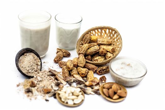 Close up of popular Indian and asian Winter drink isolated on white i.e. Kharek ka dudh or dried dates milk consisting of milk,dried dates,cashews,almonds dry fruits and sugar.