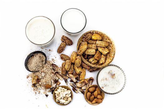 Close up of popular Indian and asian Winter drink isolated on white i.e. Kharek ka dudh or dried dates milk consisting of milk,dried dates,cashews,almonds dry fruits and sugar.