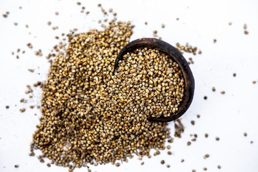 Close up of grains of pearl millet or bajra or Pennisetum glaucum in a clay bowl isolated on white.