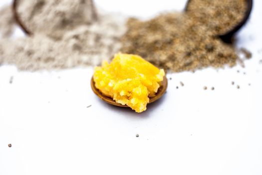 Close up of grain of pearl millet or bajra or bajri in a clay bowl with its flour and jaggery in a small glass plate ingredients for the preparation of sweets for Uttrayan or Makar shankarantri.