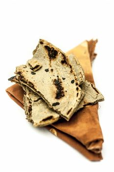 Bajri ki roti or pearl millet roti or chapati on handkerchief isolated on white.