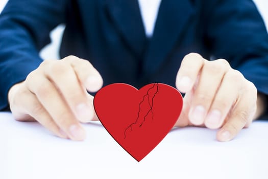 Close up of hands of business man or employee wearing blue colored suit and trying to save heart isolated.Concept of having peace and working without discrimination.