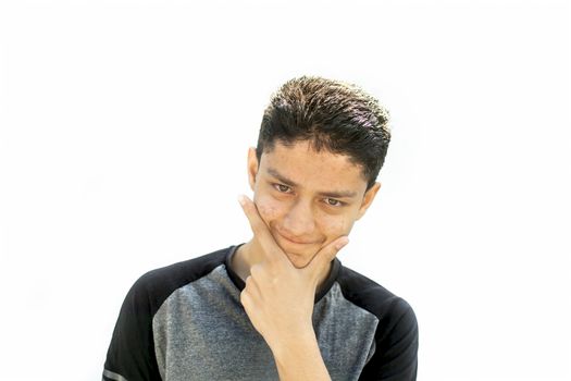 Portrait shot of young teenager or youngster isolated on white expressing some doubtfulness on his face wearing a Grey and black t shirt.