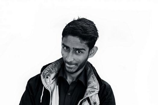 Portrait shot of a young beard man wearing brown colored shirt and a black colored jacket expressing or looking at the camera by surprised face or with curiosity or sometimes hilarious faces.