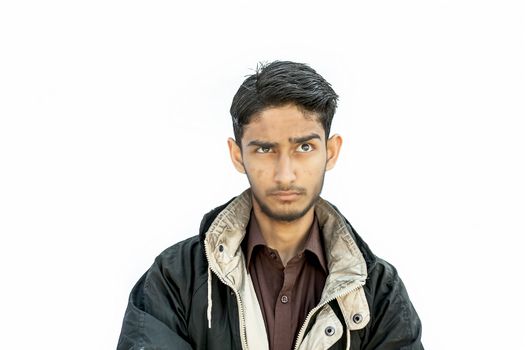 Portrait shot of young teenager or youngster isolated on white expressing some doubtfulness on his face wearing brown colored shirt and a black colored jacket with seeing up in left side.