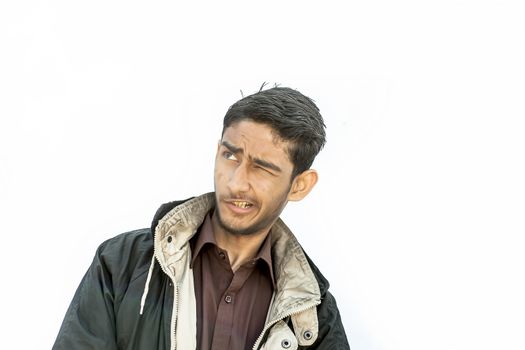 Portrait shot of a young beard man wearing brown colored shirt and a black colored jacket expressing or looking at the camera by surprised face or with curiosity or sometimes hilarious faces.