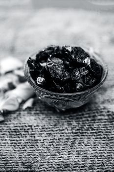 Close up of shot of raw organic dates or khajoor or Phoenix dactylifera in a glass bowl on a gunny bag background.