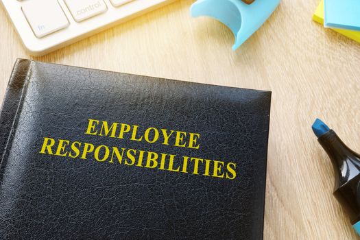Book about Employee responsibilities on an office table.