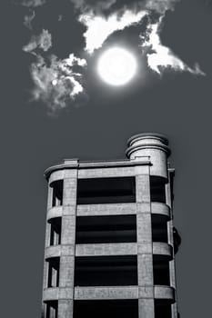 Architectural minimalistic shot of white colored building with sun and clouds.