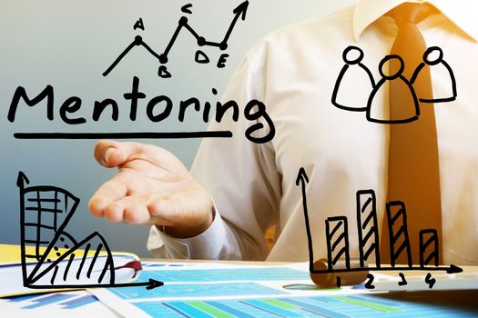 Mentoring concept. Mentor at the table in the office.