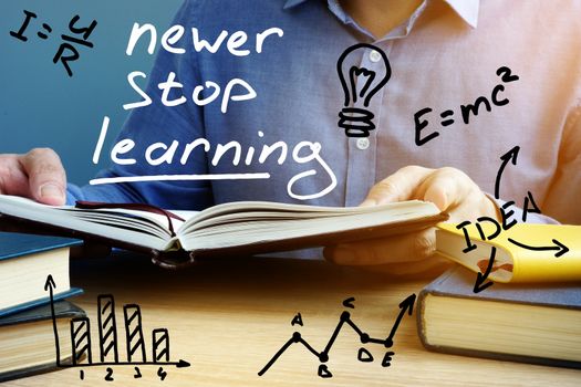 Never stop learning. Man holding open book.