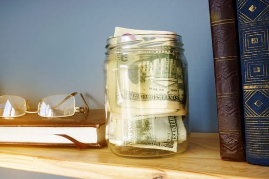 Jar with money on a shelf. Savings and home finances.