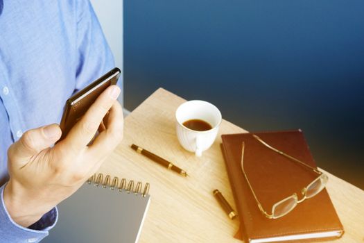 Man reading message on a smartphone. Workplace in the office.