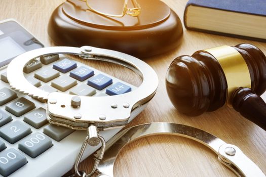 Handcuffs, gavel and calculator. Financial fraud.
