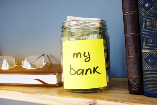 Jar with sign my bank and dollar bills. Savings concept.