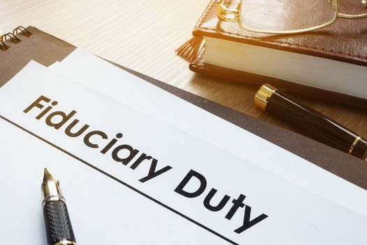 Documents with title fiduciary duty on a desk.