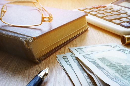 Pension savings. Money, glasses and pills on a desk.