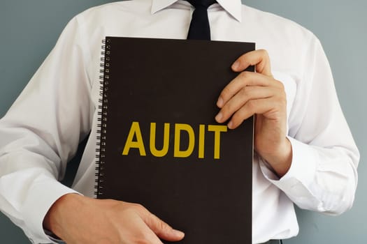 Audit concept. Auditor is holding book.