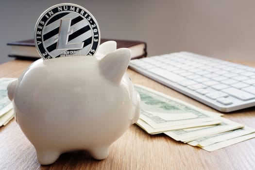 Savings in cryptocurrency. Litecoin and piggy bank.