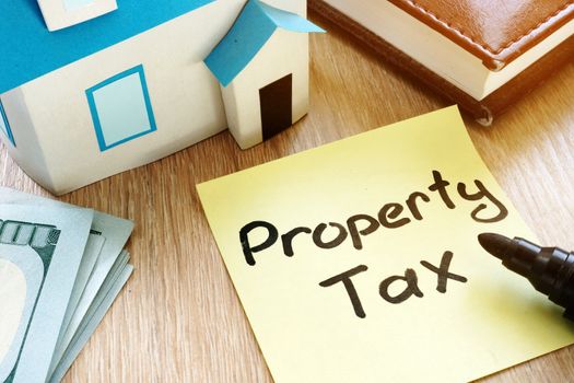 Memo stick with words Property tax and model of house.