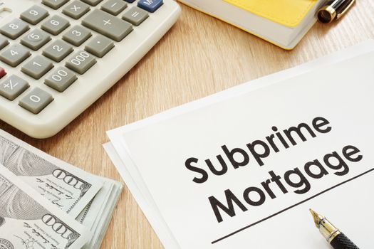 Subprime mortgage form, calculator and pen.