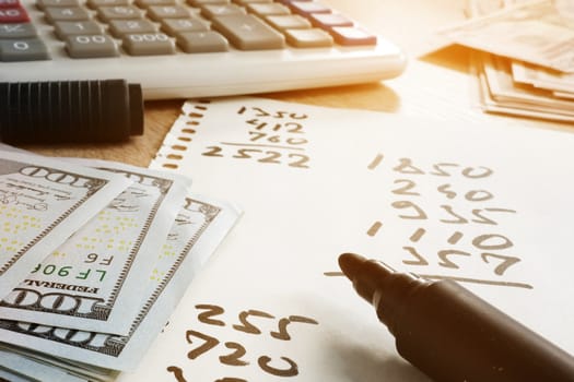 Home finances concept. Paper with calculations, calculator and money.