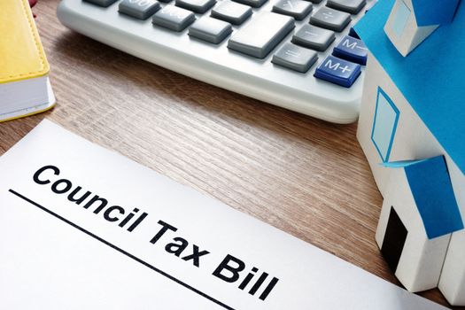 Council Tax Bill and model of house on a desk.