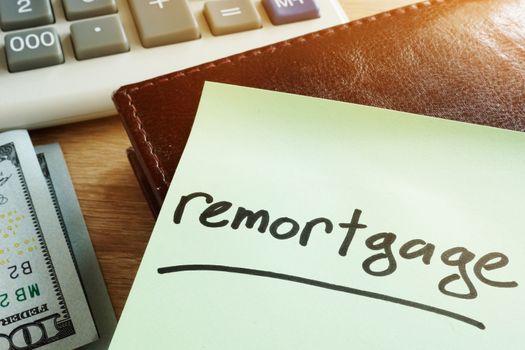Remortgage concept. Memo stick, calculator and money.