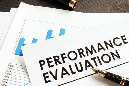 Documents about performance evaluation on a desk.