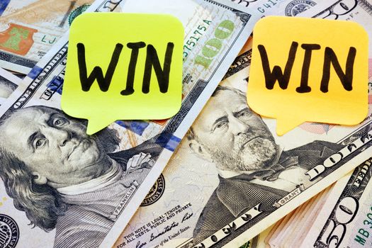 Memo sticks with words win win and dollar bills.