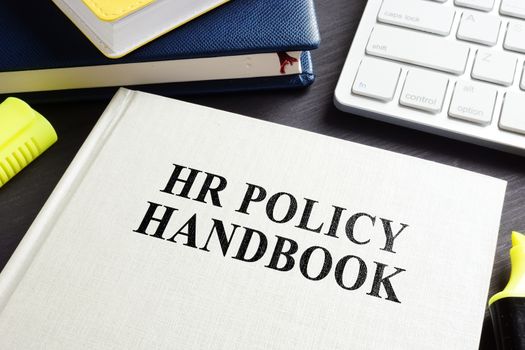 HR policy handbook on an office desk.