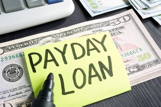 Payday loans concept. Dollar banknotes and calculator.
