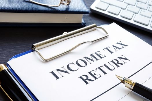 Income tax return documents and pen on a desk.