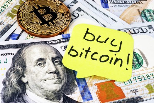 Buy Bitcoin written on a memo stick. Cryptocurrency trading.