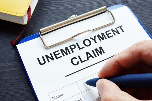 Man is filling in Unemployment claim form.