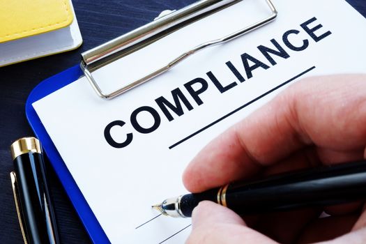 Man is filling in a compliance form.