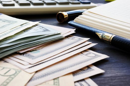 Personal finances. Dollar banknotes, notepad and calculator.