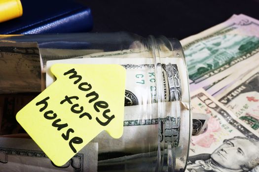 Money for house. Jar with dollars on a desk.